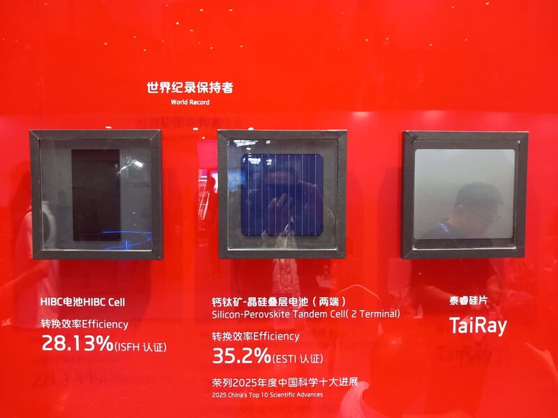 Three framed solar cells mounted on a red wall labelled World Record, with certified efficiency figures beneath each.